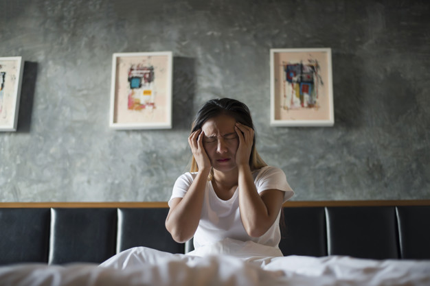 depressed woman with headache hand holding her head bed 1150 4136 1
